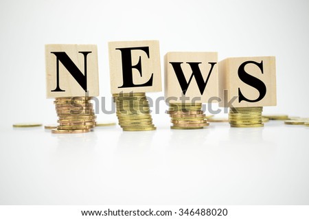 Wooden block with stacked coins with word News written