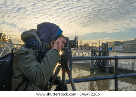 Photographer taking picture using tripod, dslr camera and ND filter