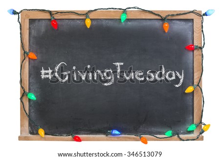 Hashtag Giving Tuesday written in white chalk on a black chalkboard surrounded with colorful lights isolated on white