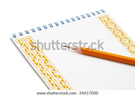 Yellow pencil on spiral notebook with an ornament