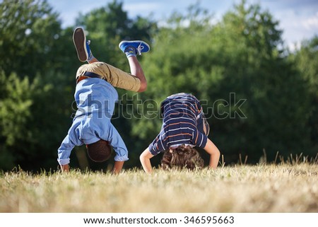 Two boys making a somersault and having fun at the park Royalty-Free Stock Photo #346595663