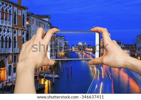 Taking pictures on mobile smart phone in View of the Grand Canal and Basilica Santa Maria della Salute at night , Venice, Italy 