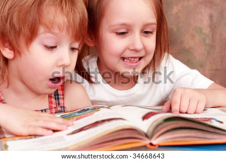 girl and boy friendly reading an interesting book
