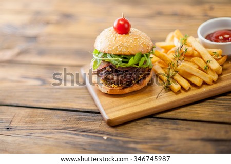 Home made burgers on wooden background with sauce