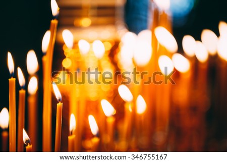 Group of burning church candles at dark background