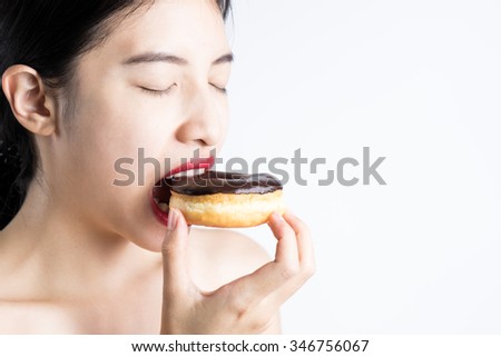 Woman eating donut on white background