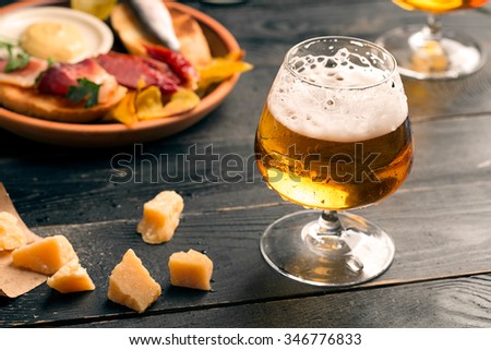 Two glasses of beer on the black table with snacks Royalty-Free Stock Photo #346776833