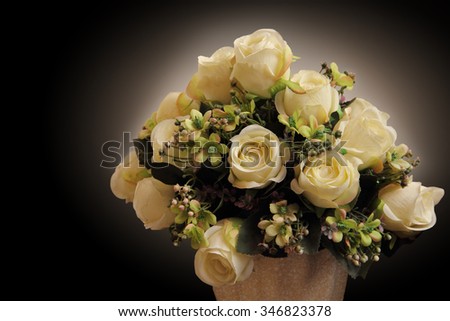 White roses in a vase over dark background