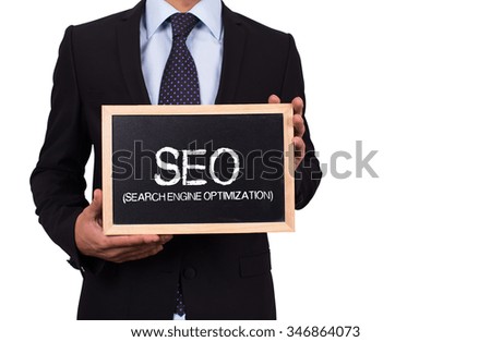 Businessman holding mini blackboard with SEO message