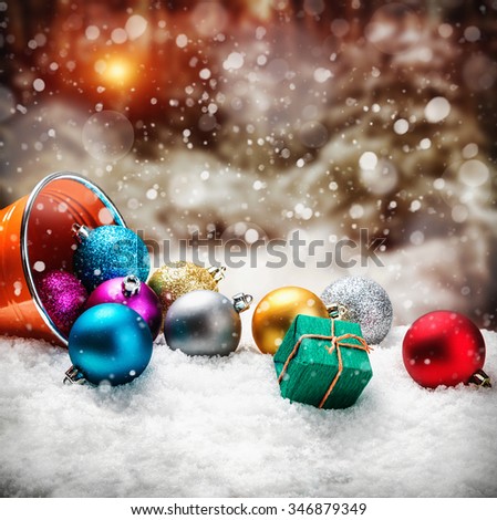 Christmas balls and gifts in the snow against the backdrop of the winter forest