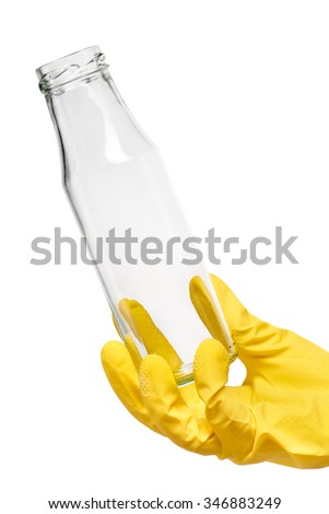 Close up of female hand in yellow protective rubber glove holding empty clean transparent glass milk bottle against white background. Clipping path for bottle border included.