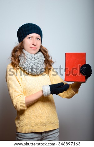 Beautiful girl with books in their hands, in a bright yellow color, lifestyle winter clothes studio photo isolated on a gray background