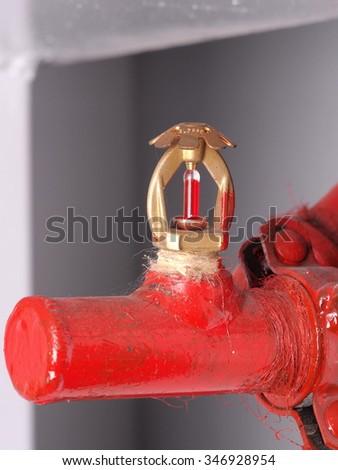 Single real life installed sprinkler head with brass and chrome armature, glass vial with red fluid and red supply pipe, Australia 2015
 