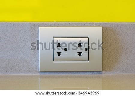 Gray double plug socket on wall