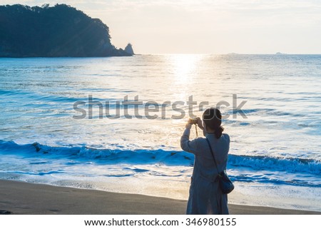 Asian woman take a picture of sea