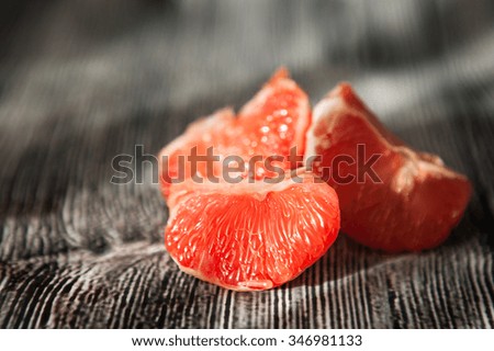 Juicy fresh pink grapefruit on the wooden background, selective focus