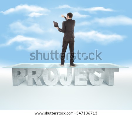 Confident business man standing on the PROJECT table design, with open laptop and indicates the direction