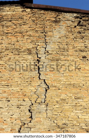 a fragment of a brick wall with a crack and the sky