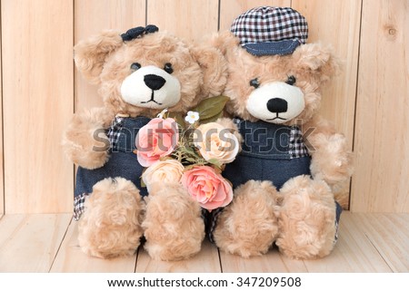 couple teddy bears with roses on wood background, two teddy bears love concept