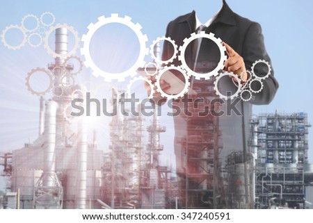 Double exposure of success businessman using digital tablet with  oil refinery industry in metallic color style use as metal style of heavy industry background