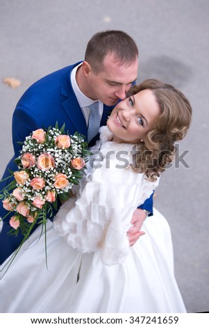 Autumn wedding, the groom embraces the bride