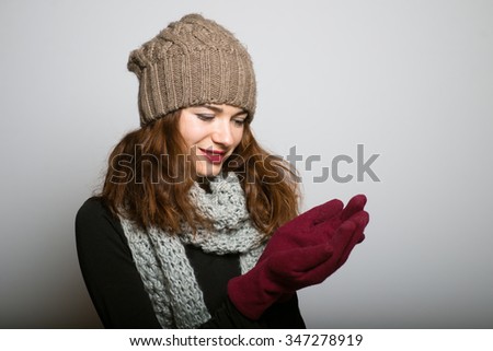 Cute girl holding an invisible a present Christmas and New Year concept isolated studio shot on a gray background