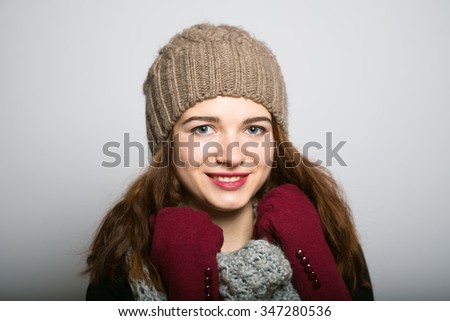 Lovely girl in winter gloves, Christmas and New Year concept isolated studio shot on a gray background