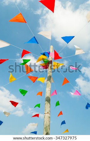 Vertical picture of colorful festive bunting flags against, on blue and clouds sky in Thailand