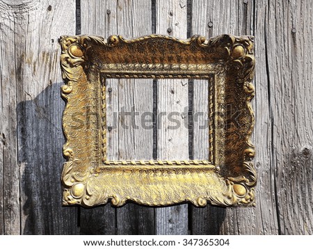 Old golden frame on a wooden wall