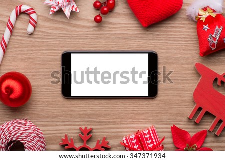 Mobile phone and the Christmas and New Year decoration on a wooden background