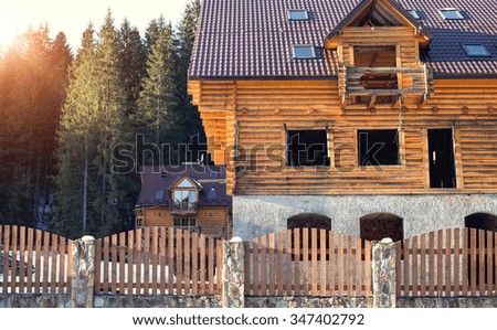 wooden house in winter forest in mountains.
