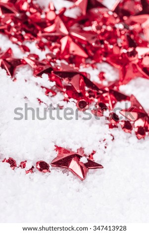 Detail of Christmas decoration chain on a snowy background. Selective focus image with shallow depth of field