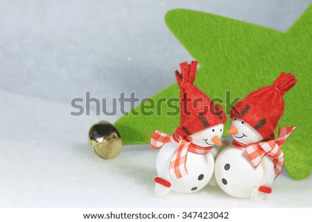 Funny snowmen telling a secret to each other, on winter background