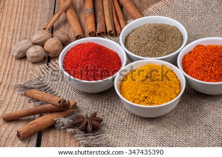 Spices in bowls on wooden background