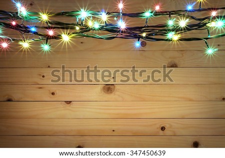 Christmas light boarder on wooden background. Royalty-Free Stock Photo #347450639