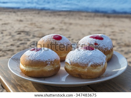Sweet donuts are a traditional Jewish food for Hanukkah holiday. The picture was taken on sandy beach of the Red Sea, Israel