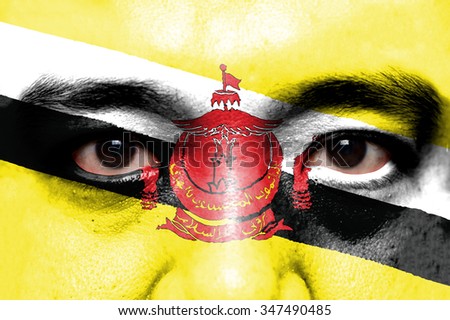 Human face painted with flag of BBrunei Darussalam.