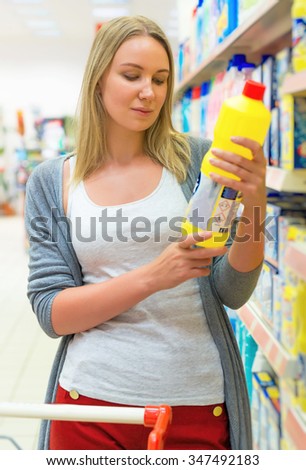 Woman choosing household chemicals in the store.