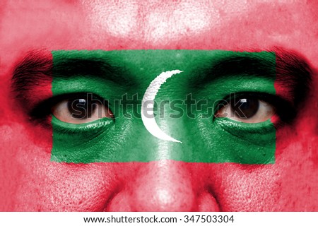 Human face painted with flag of Maldives.