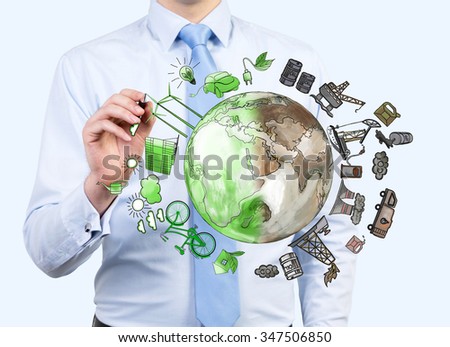 man pointing at the brown picture of oil industry components and green eco energy arranged in circle, earth in the centre, concept of environment