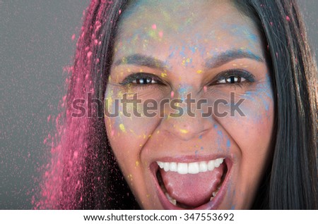 Beautiful young brunette girl with colorful decorated face celebrating, closeup