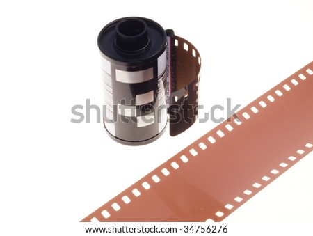 35mm photographic negative film in container with a piece of film in front.