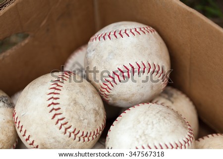 Close-up of white old baseballs in cardboard box for sale at flea market