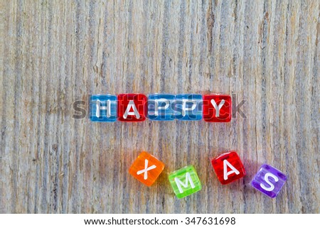 Happy xmas text made from multicolored toy cubes with letters on it.