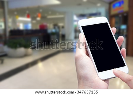 woman hand  and touch screen smart phone, shopping center or super market background