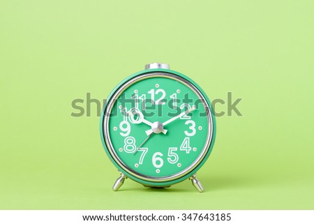 Old retro clock on green background with copy space