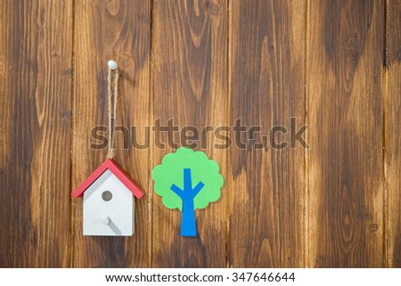 model houses and tree on wooden background, home environment