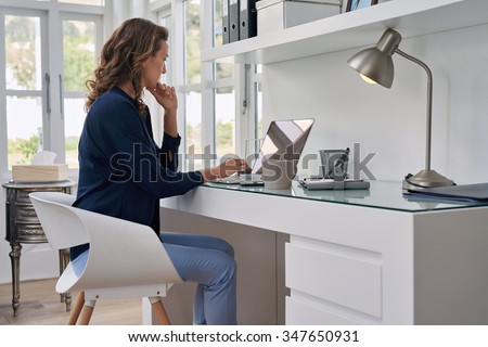 businesswoman entrepreneur working on laptop from home office space Royalty-Free Stock Photo #347650931