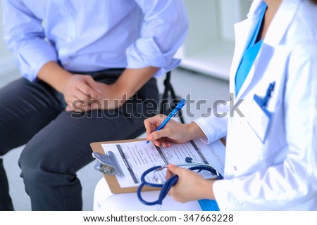 Doctor woman sitting with  male patient at the desk Royalty-Free Stock Photo #347663228
