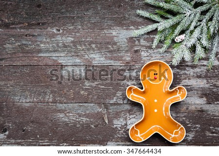 Spruce twig and Gingerbread boy tray on wooden background with copy space
